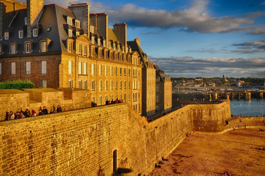 Vue des remparts de Saint-Malo au coucher du soleil, symbole de la cité corsaire bretonne, proposée dans le circuit touristique MJ Prestige.